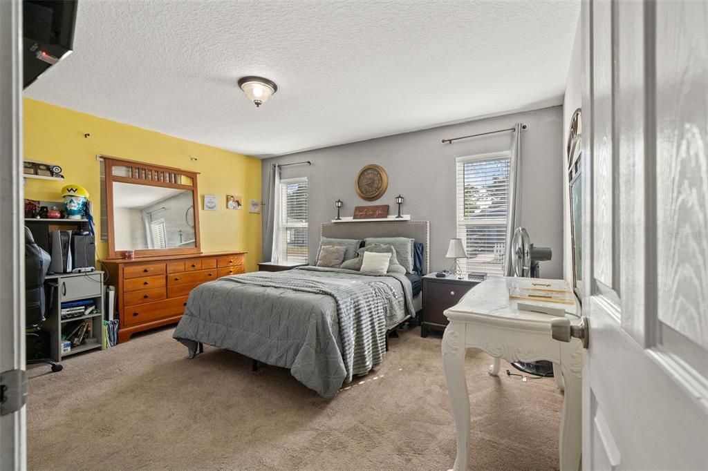 8025 Durham Drive Port Richey, FL 34668 - Photo 11 of 30 a bedroom with a bed and a chandelier