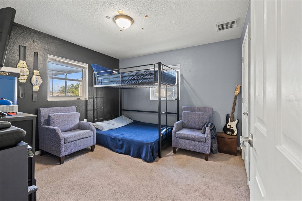 8025 Durham Drive Port Richey, FL 34668 - Photo 12 of 30 a bedroom with two beds and a couch