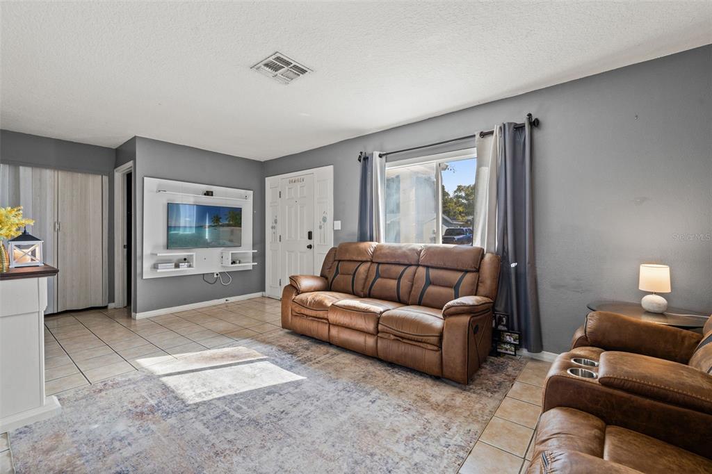 8025 Durham Drive Port Richey, FL 34668 - Photo 21 of 30 a living room with furniture and a flat screen tv