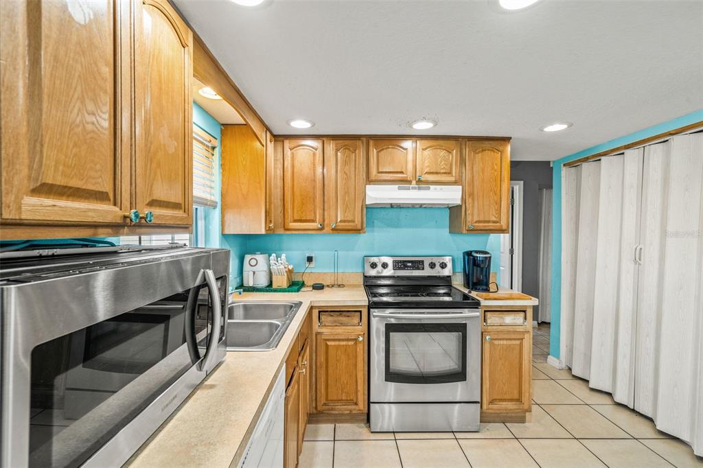 8025 Durham Drive Port Richey, FL 34668 - Photo 27 of 30 a kitchen with stainless steel appliances a stove sink and cabinets