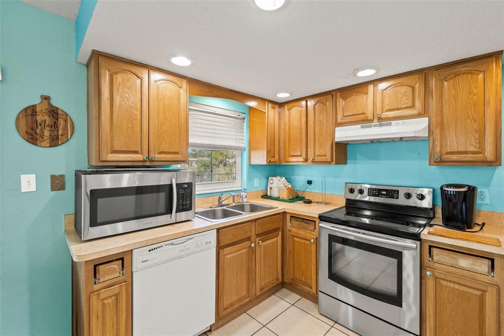 8025 Durham Drive Port Richey, FL 34668 - Photo 29 of 30 a kitchen with a stove a sink and a microwave