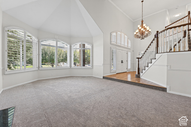 10664 Trail Ridge Circle Sandy, UT 84092 - Photo 4 of 113 Vaulted ceilings, arched windows with plantation shutters, wood-finish flooring at entry, grand staircase with wood railing, and an ornate chandelier