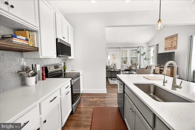 a kitchen with stainless steel appliances granite countertop a sink and dishwasher a stove top oven with wooden floor