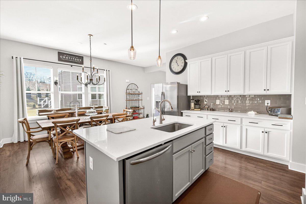 2896 Town View Circle New Windsor, MD 21776 - Photo 19 of 45 a kitchen with a stove a sink a kitchen island with wooden cabinets and couches
