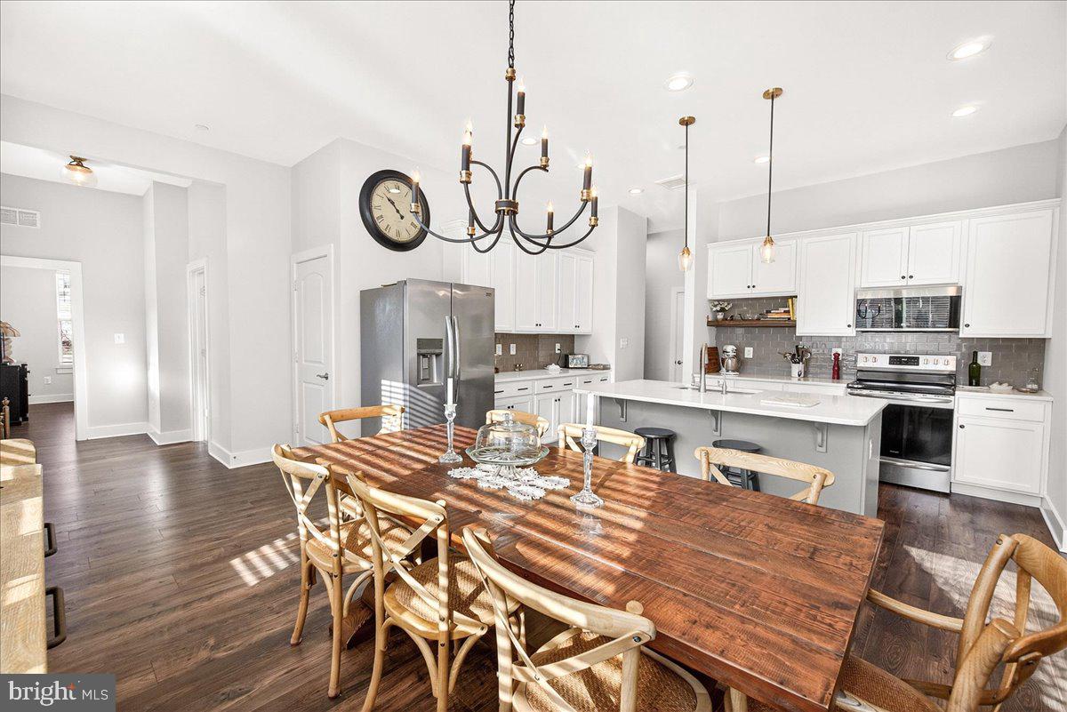 2896 Town View Circle New Windsor, MD 21776 - Photo 24 of 45 a kitchen with stainless steel appliances granite countertop a kitchen island a stove a table and chairs with wooden floor