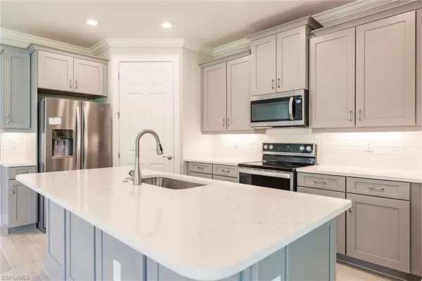 a kitchen with stainless steel appliances granite countertop a sink and a refrigerator