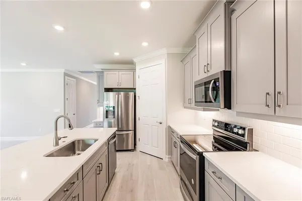 a kitchen with stainless steel appliances white cabinets and a stove top oven