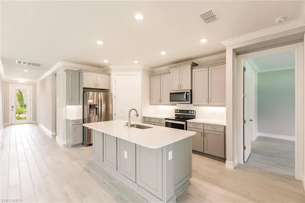 a kitchen with kitchen island a counter top space cabinets and stainless steel appliances
