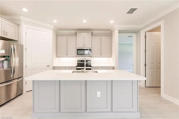 a kitchen with stainless steel appliances a stove microwave and sink