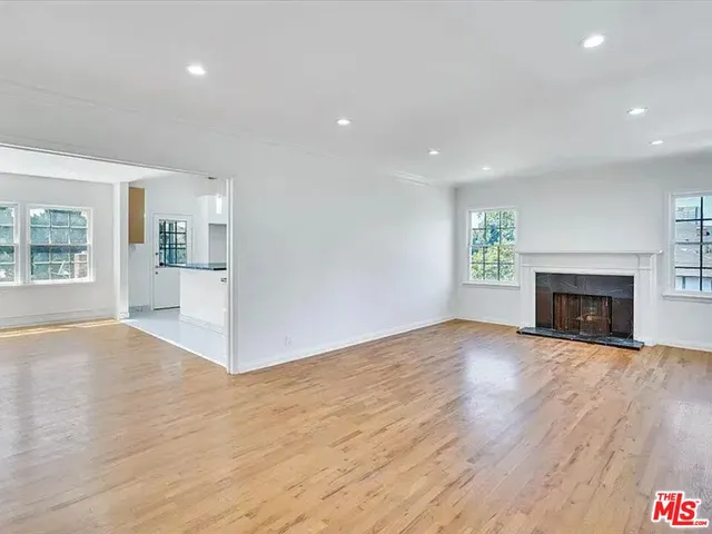 a view of empty room with wooden floor and fireplace