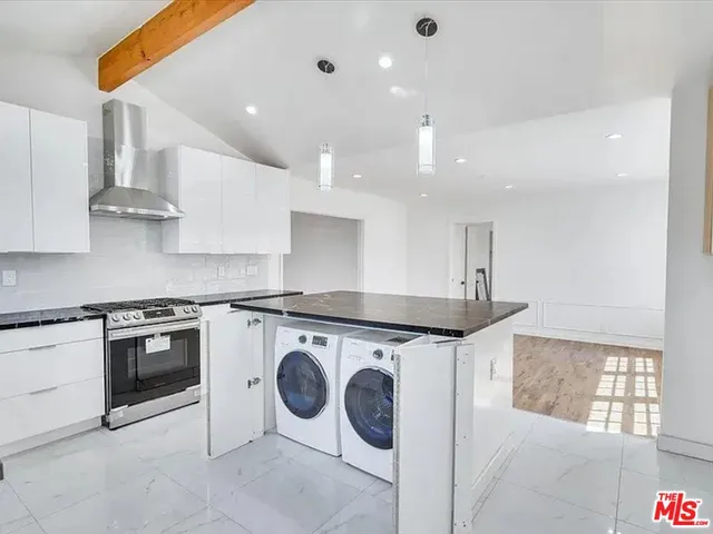 a kitchen with a stove top oven and cabinets
