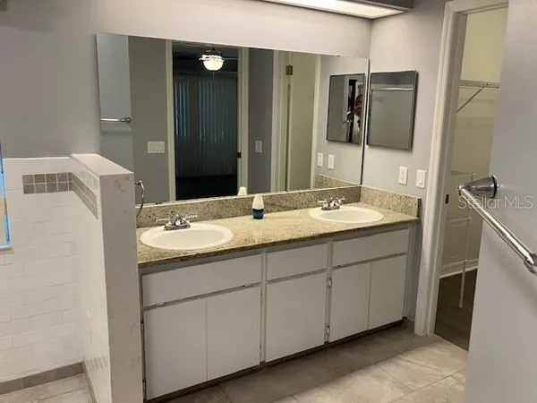 a bathroom with a double vanity sink and mirror