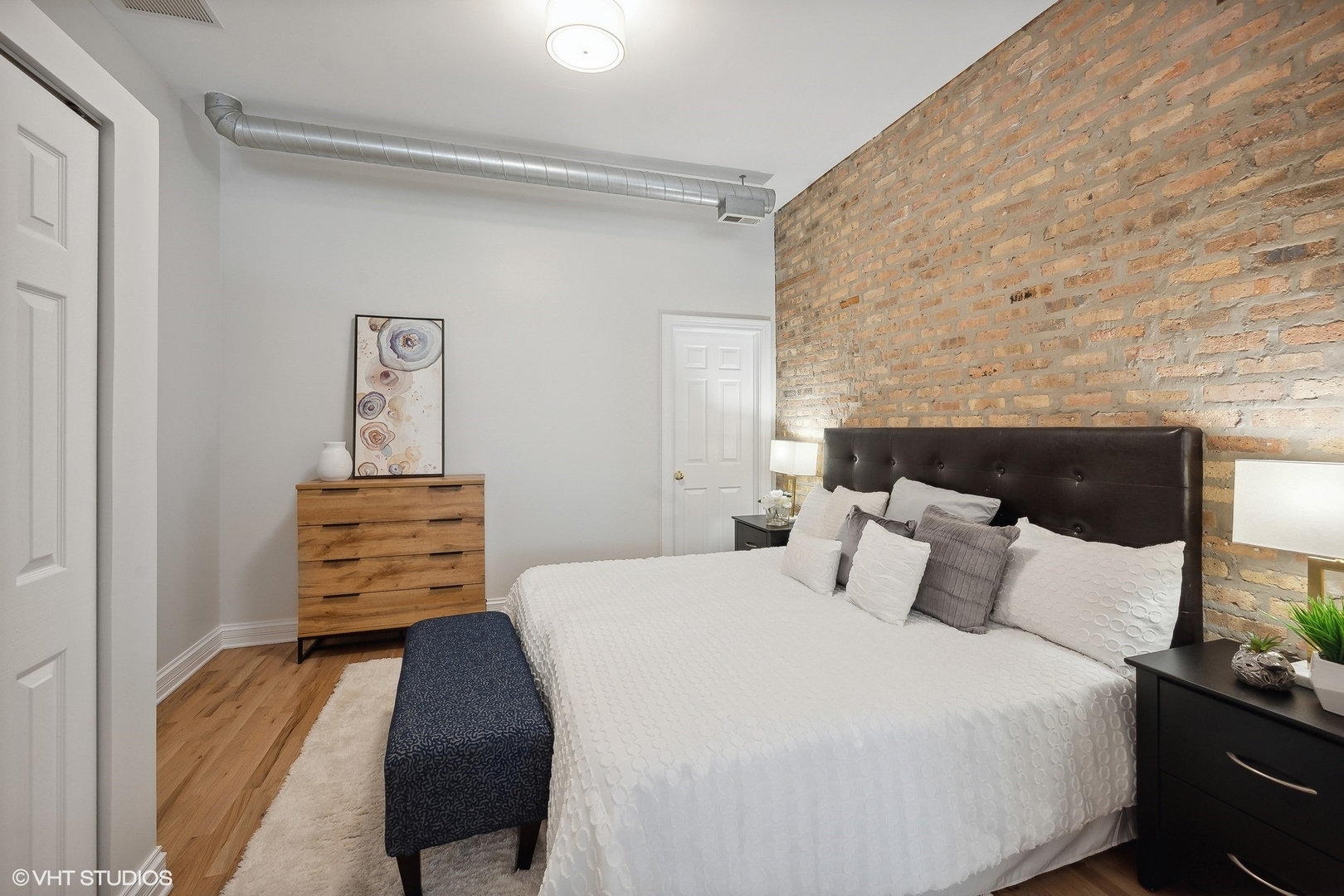 1245 West George Street, Unit 203 Chicago, IL 60657 - Photo 8 of 15 a bedroom with a bed and dresser