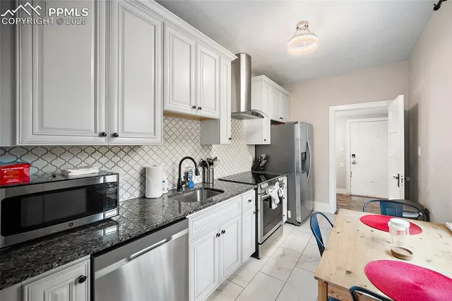 a kitchen with stainless steel appliances granite countertop a sink stove and cabinets