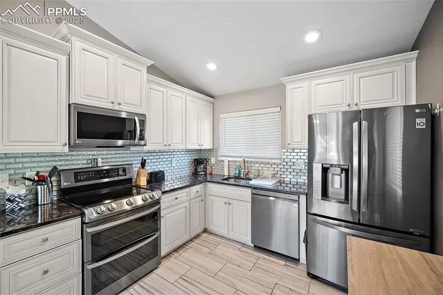 a kitchen with stainless steel appliances a refrigerator sink and microwave
