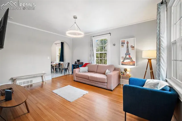 a living room with furniture wooden floor and a chandelier