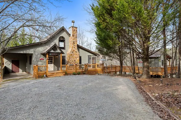 a view of a house with a big yard and large trees