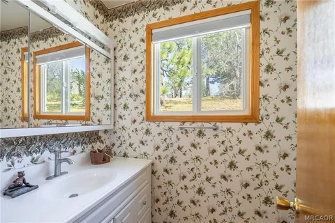a bathroom with a sink a window and a mirror