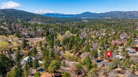 an aerial view of a house with a yard and a large tree