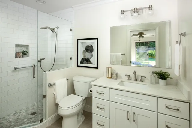 a bathroom with a sink a toilet and shower