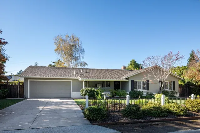 a front view of a house with a yard and potted plants