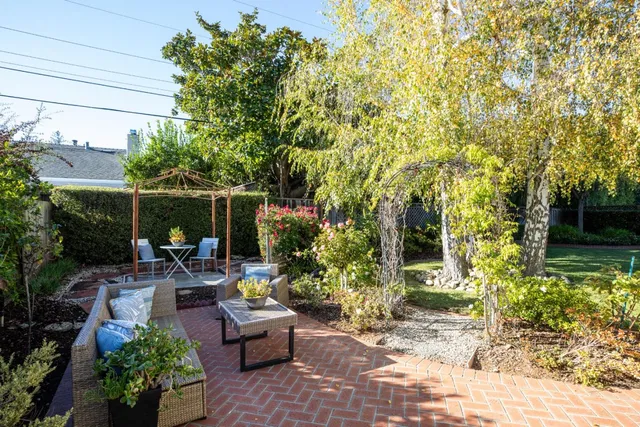 a backyard of a house with fountain table and chairs