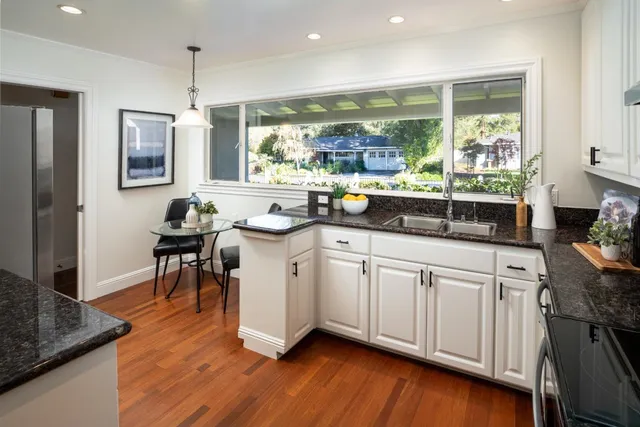 a kitchen with sink cabinets and wooden floor