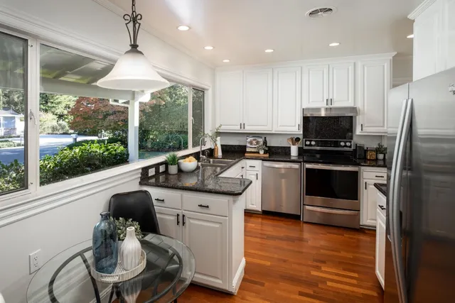 a kitchen with a sink stainless steel appliances and window