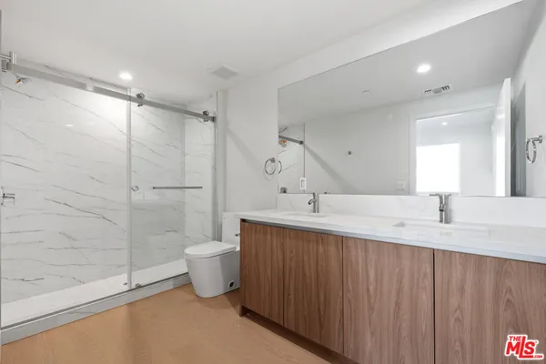 a bathroom with a granite countertop sink a toilet and a shower