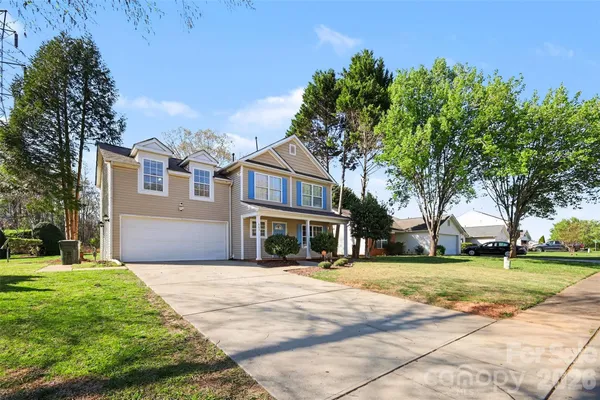 a view of a house with a big yard and large trees
