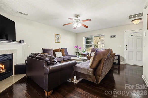 a living room with furniture a flat screen tv and a fireplace
