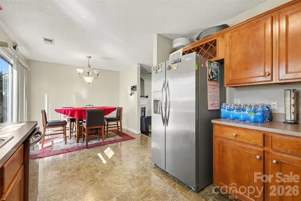 a kitchen with stainless steel appliances kitchen island granite countertop a refrigerator and a table