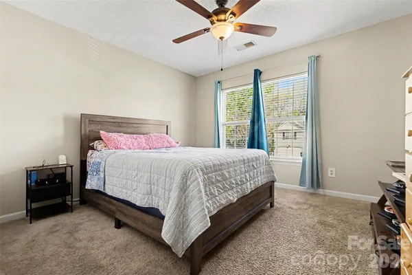a bed sitting in a bedroom next to a window