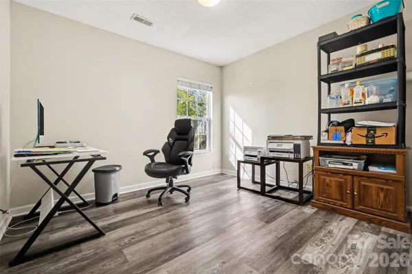 a view of a workspace with furniture and a bookshelf