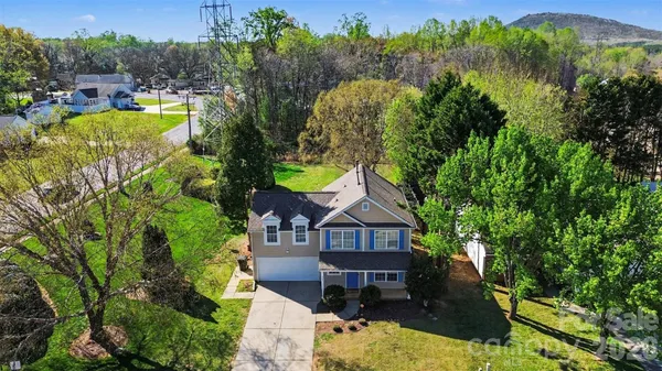 an aerial view of a house with swimming pool and mountain view