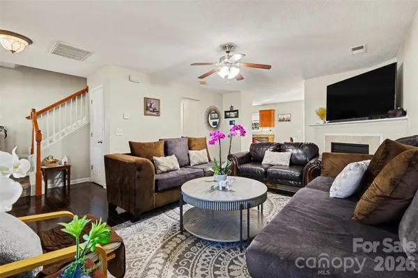 a living room with furniture a flat screen tv and kitchen view