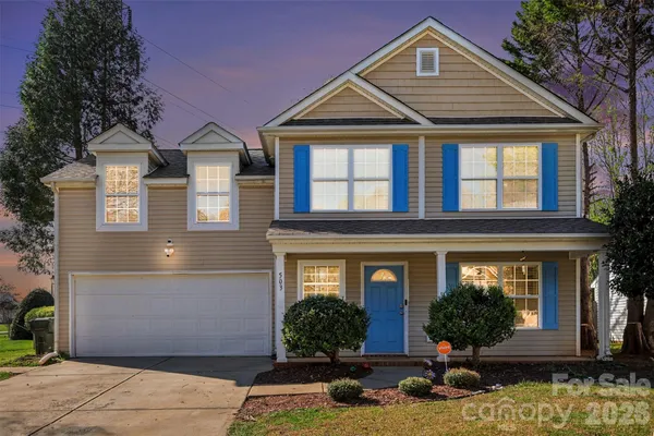 a front view of a house with yard garage and glass windows