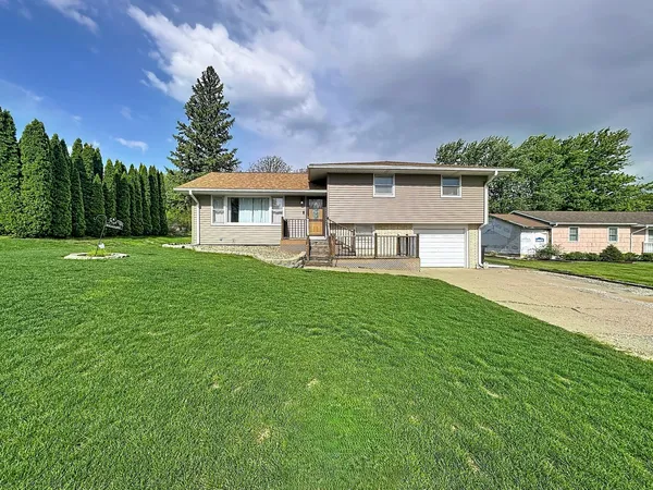 a view of a house with a big yard and large trees