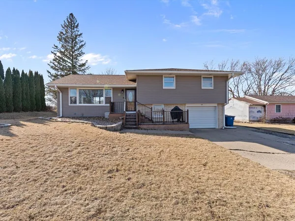 a front view of house with yard and trees in the background