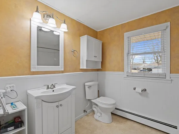 a bathroom with a toilet sink and mirror