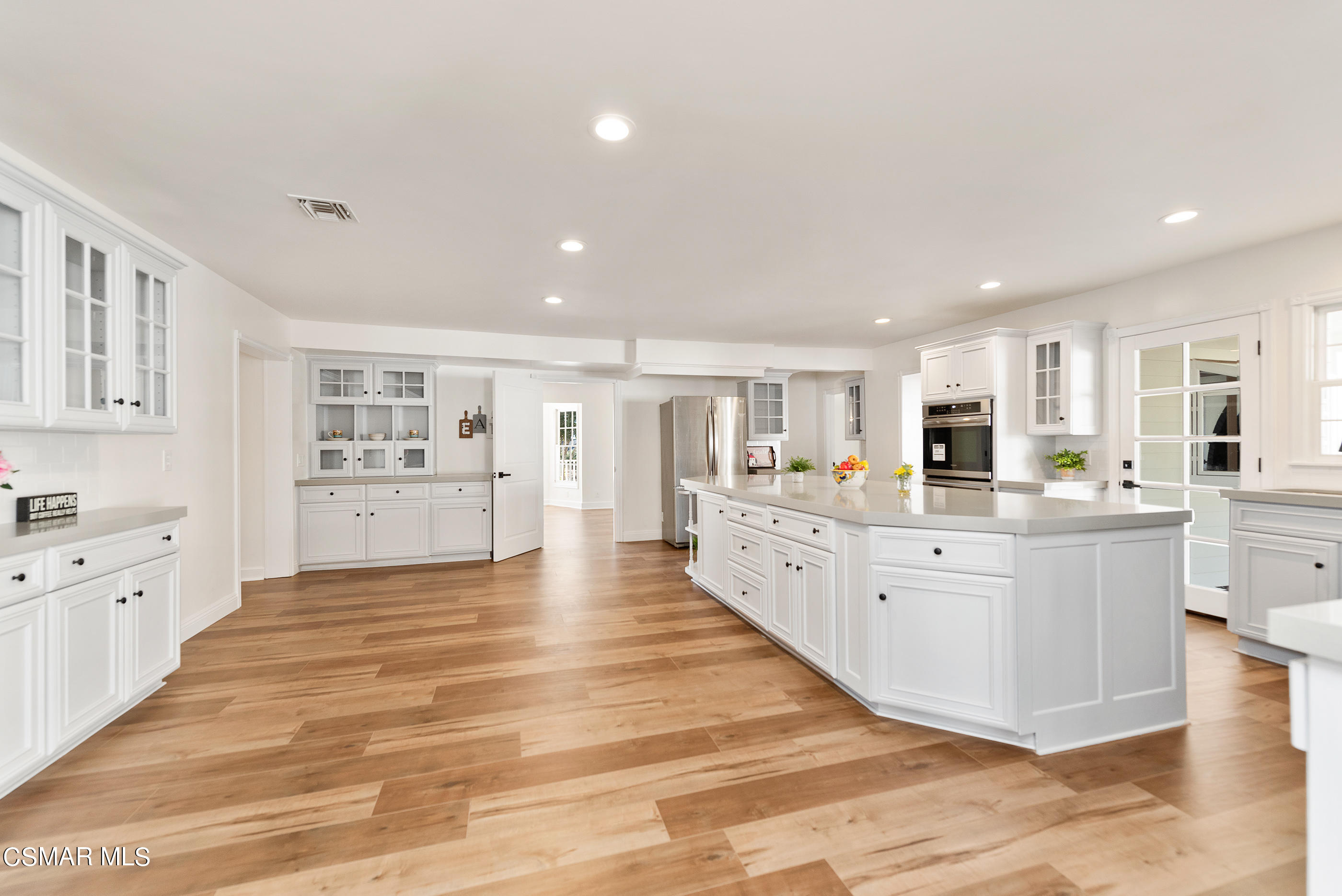 2959 Happy Lane Simi Valley, CA 93065 - Photo 25 of 92 a large white kitchen with kitchen island a sink a center island and windows