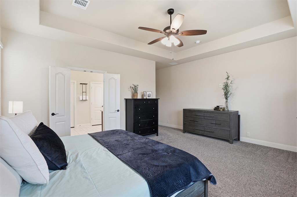 4002 Grove Valley Road Midlothian, TX 76065 - Photo 19 of 40 a bedroom with a bed and a chandelier