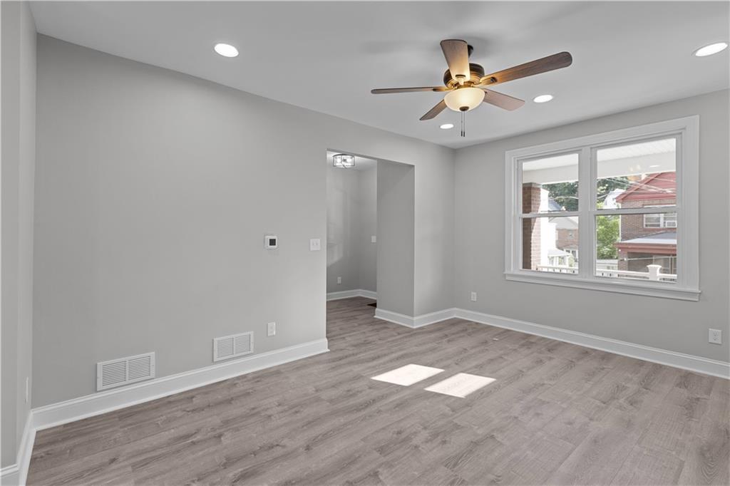 748 Anaheim Street Pittsburgh, PA 15219 - Photo 11 of 29 an empty room with wooden floor fan and windows