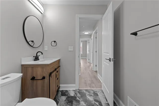 a bathroom with a sink a toilet and a mirror