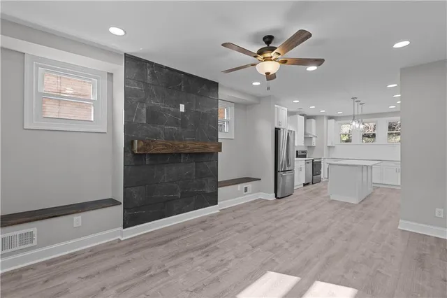 a view of a livingroom with a ceiling fan and wooden floor
