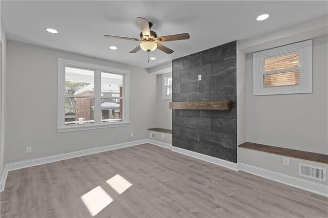 a view of an empty room with a window and wooden floor