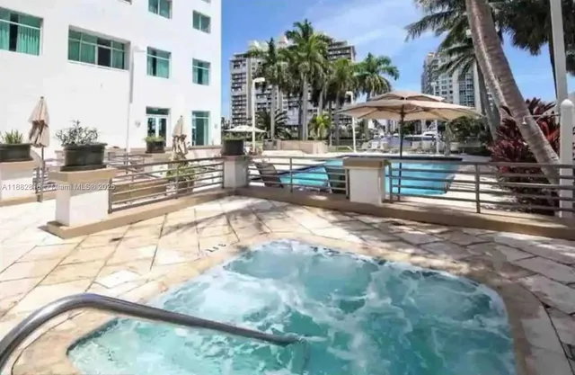 a view of swimming pool with a lawn chairs and palm tree