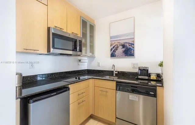 a kitchen with granite countertop a stove sink and microwave