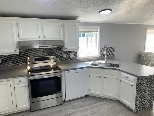 a kitchen with granite countertop white cabinets and appliances
