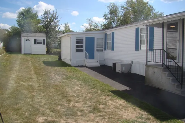 a view of a house with backyard and sitting area